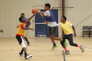 James Kent of E.B. Jordan Homes passes the basketball to teammate Ny’Saiah Allen while Blessed Peppers and Brandon Kent Davis of Whitfield Homes defend on the play.