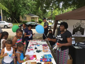 Diane Davis of Crossroads Street Ministry hands out goodies to the children who flocked around their tent at the Wilson Housing Authority and The Five Points Association's Community Fun Day and Health Fair Expo. Crossroads offers support to individuals and families who are going through tough times.