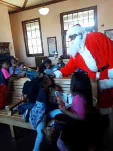 Santa visits with children from the Wilson Housing Authority while they wait to board the Polar Express for a magic carpet ride aboard the Christmas-themed train.