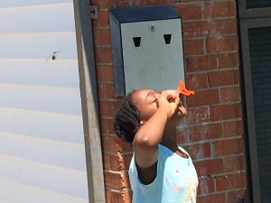 Aniyah Barnes of Whitfield Homes sends homemade dish soap and corn starch bubbles skyward through her just completed pipe cleaner bubble blower that she made at the Wilson Housing Authority's Arts Camp.